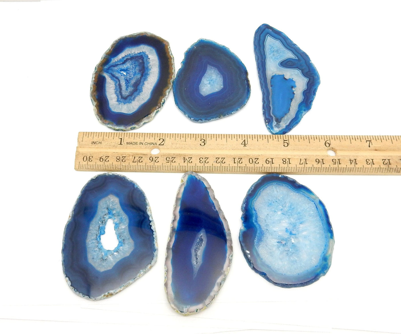 blue agate slices in a row with a ruler between them