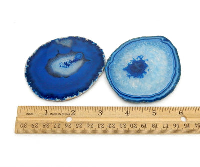 2 blue agate  slices next to a ruler