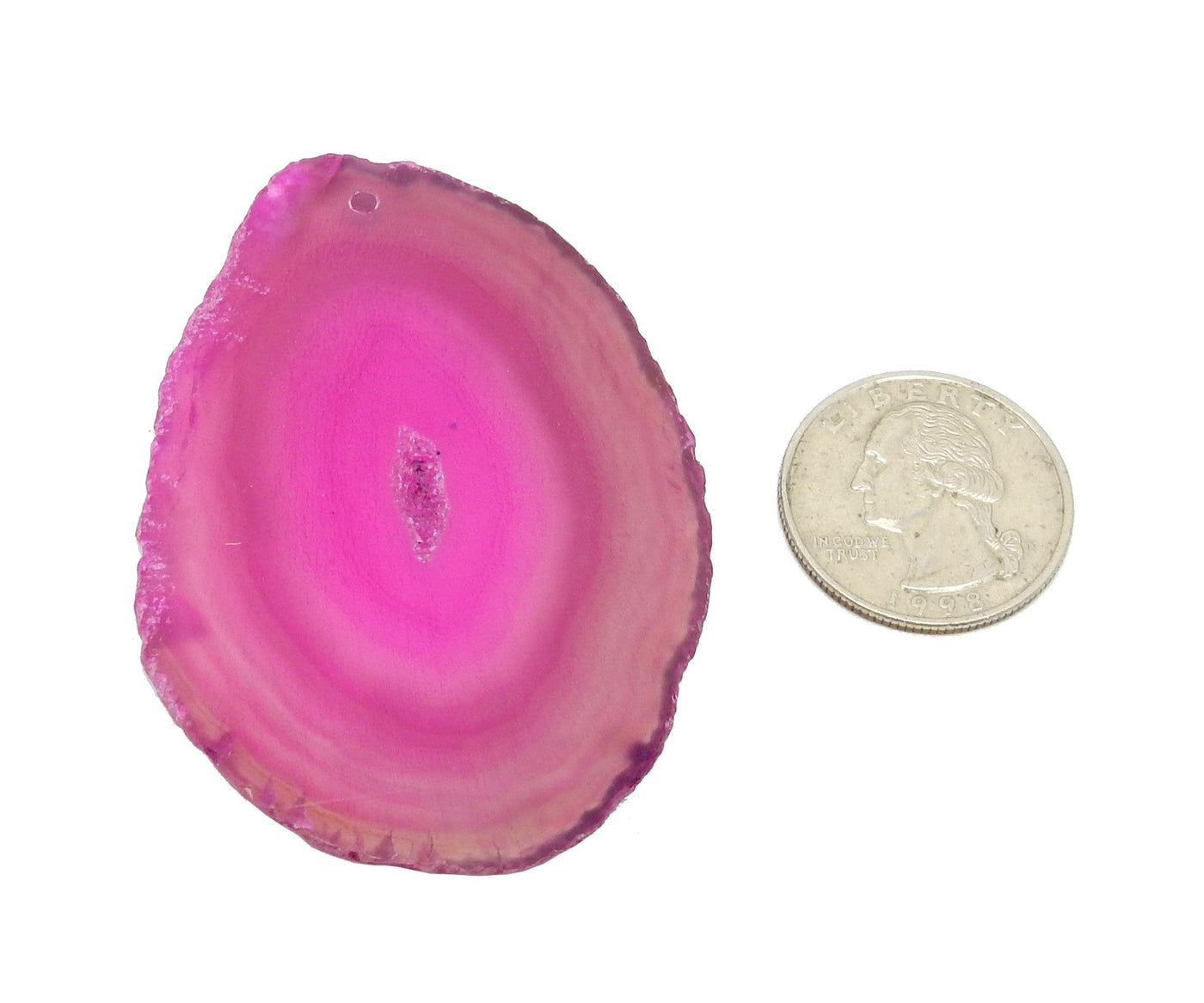 Pink agate slice drilled next to a Quarter on White Background. 