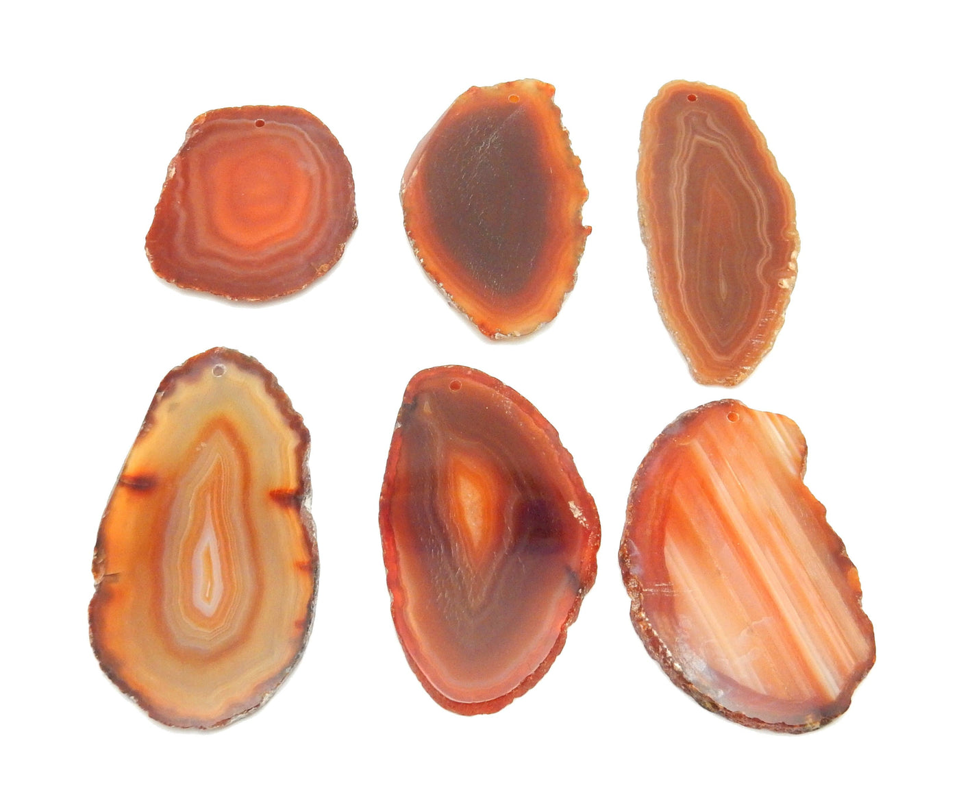 6 Red Agate Slices Drilled on White Background.