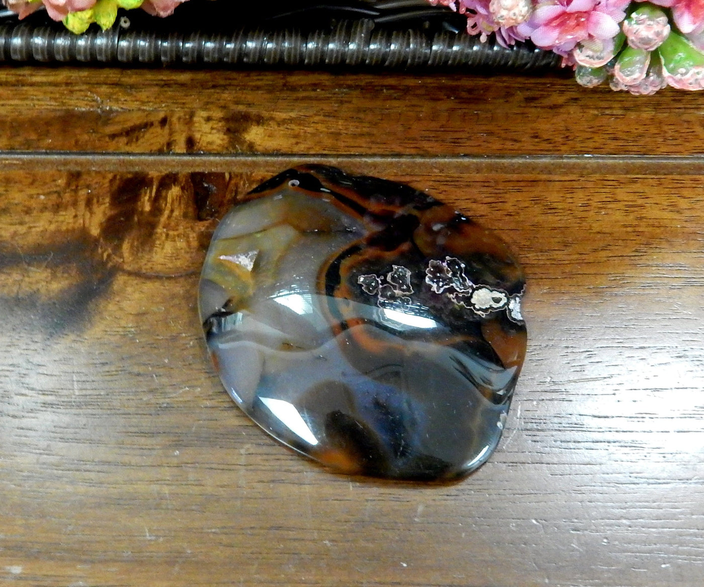Black Drilled Freeform Agate Slices With Polished Edge on Wooden Background.