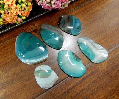 Side Angle 6 Green FreeForm Agate Slices with Polished Edge on Wooden Background.