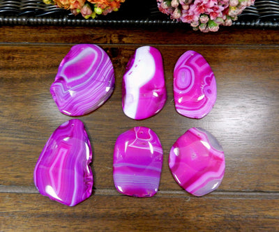 6 Pink FreeForm Agate Slices with Polished Edge on Wooden Background.