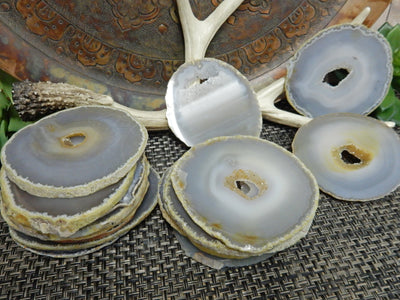 Natural Agate Slices - Extra Grade Polished Agate - Coaster Size with Open Druzy Center - 2 stacked piles and 3 leaning on a boardg