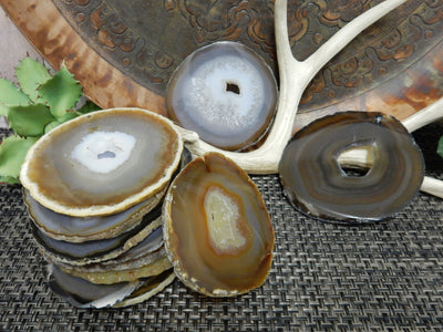 Natural Dark Agate Slices - in a pile on a table and a few scattered on the table