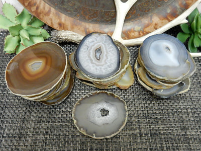 Natural Dark Agate Slices - in  3 piles on a table and one by itself