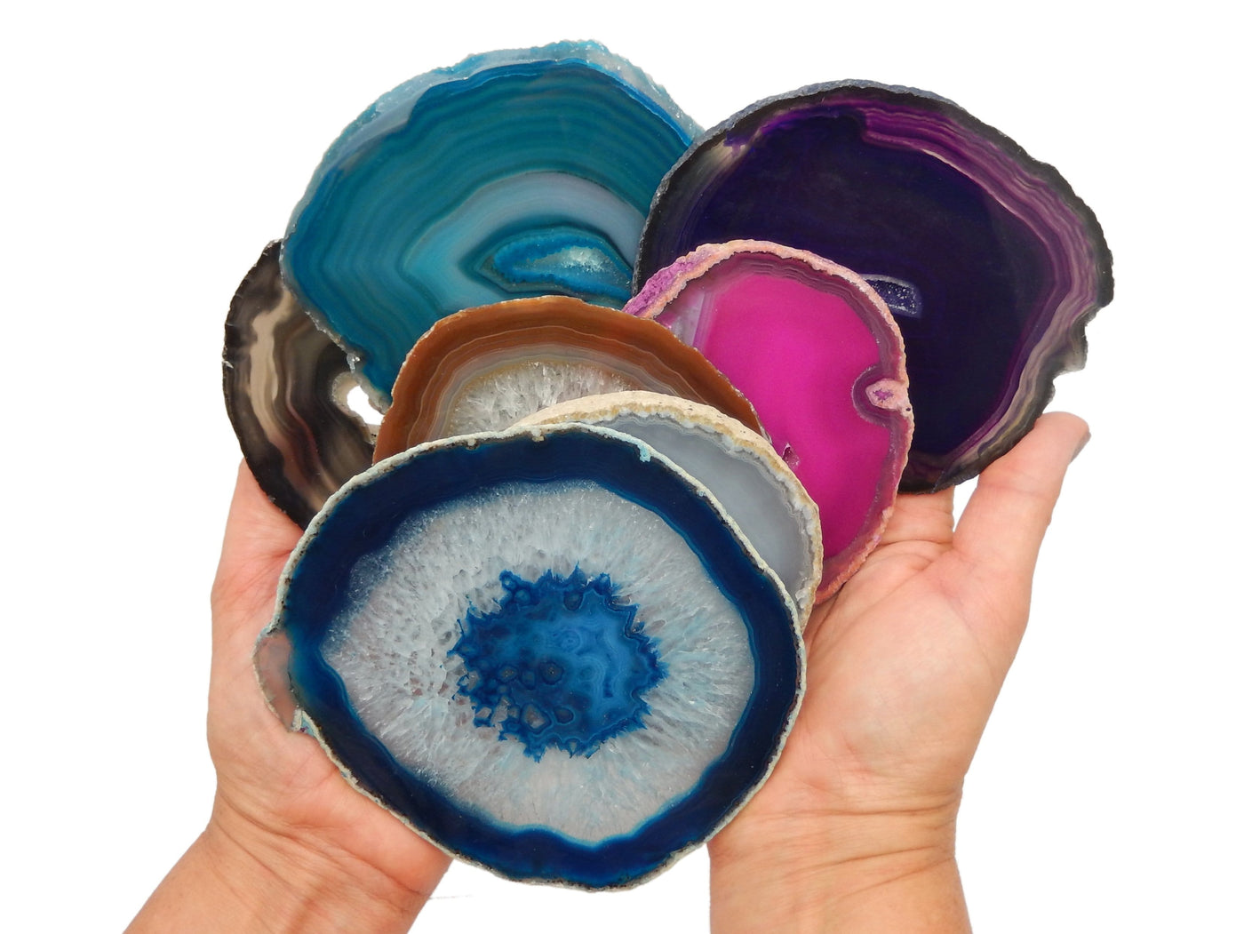 assorted colors of the #5 agate slices that are available in hands to show size