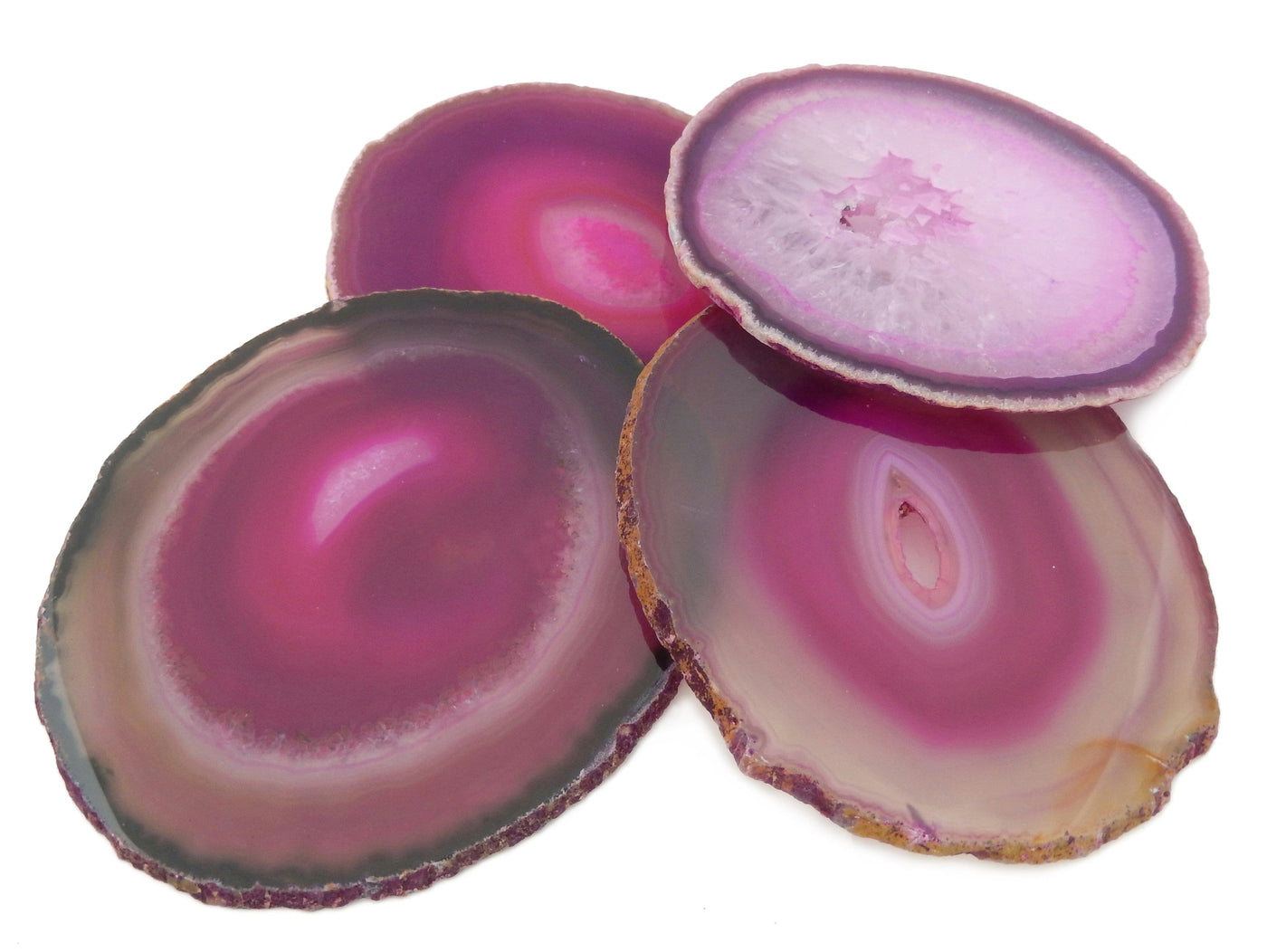 Four Pink Agate Slices #6 on a table showing different colors and markings in the pink
