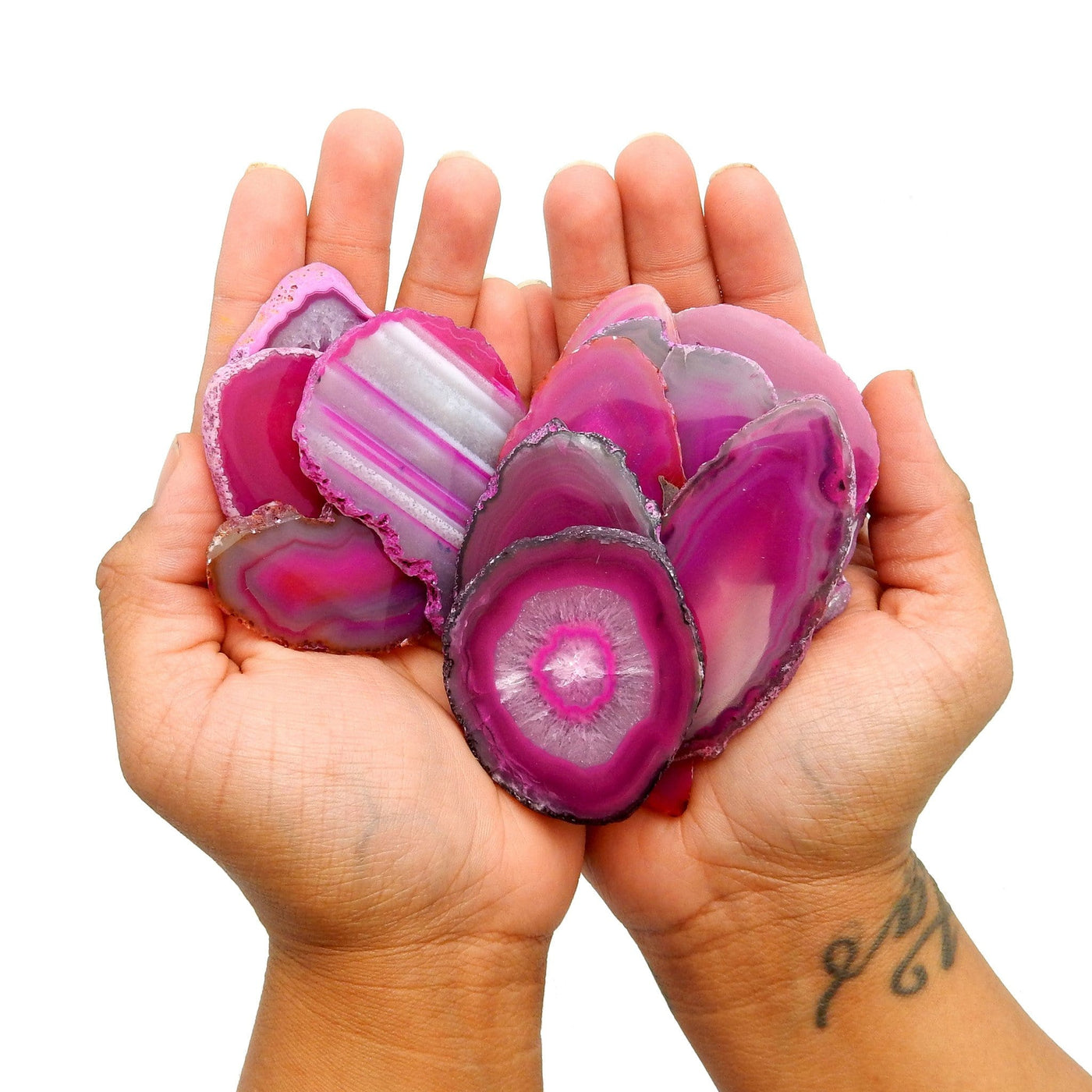 multiple pink agate slices in hand for size reference 