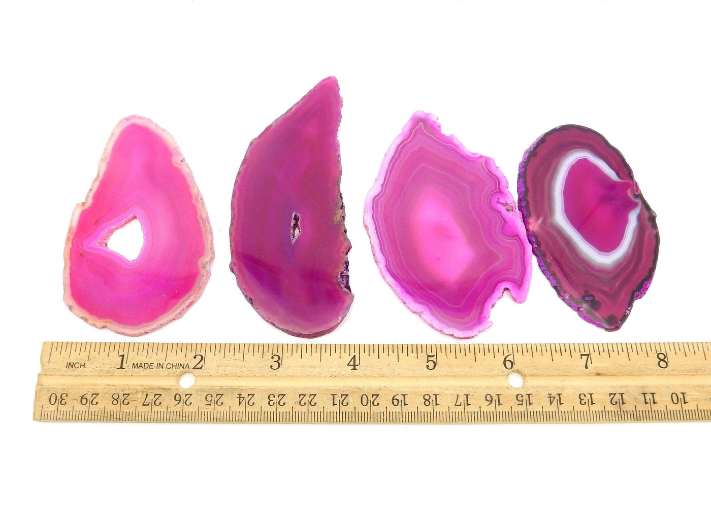 pink agate slices next to a ruler
