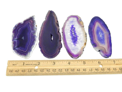 purple agate slices next to a ruler