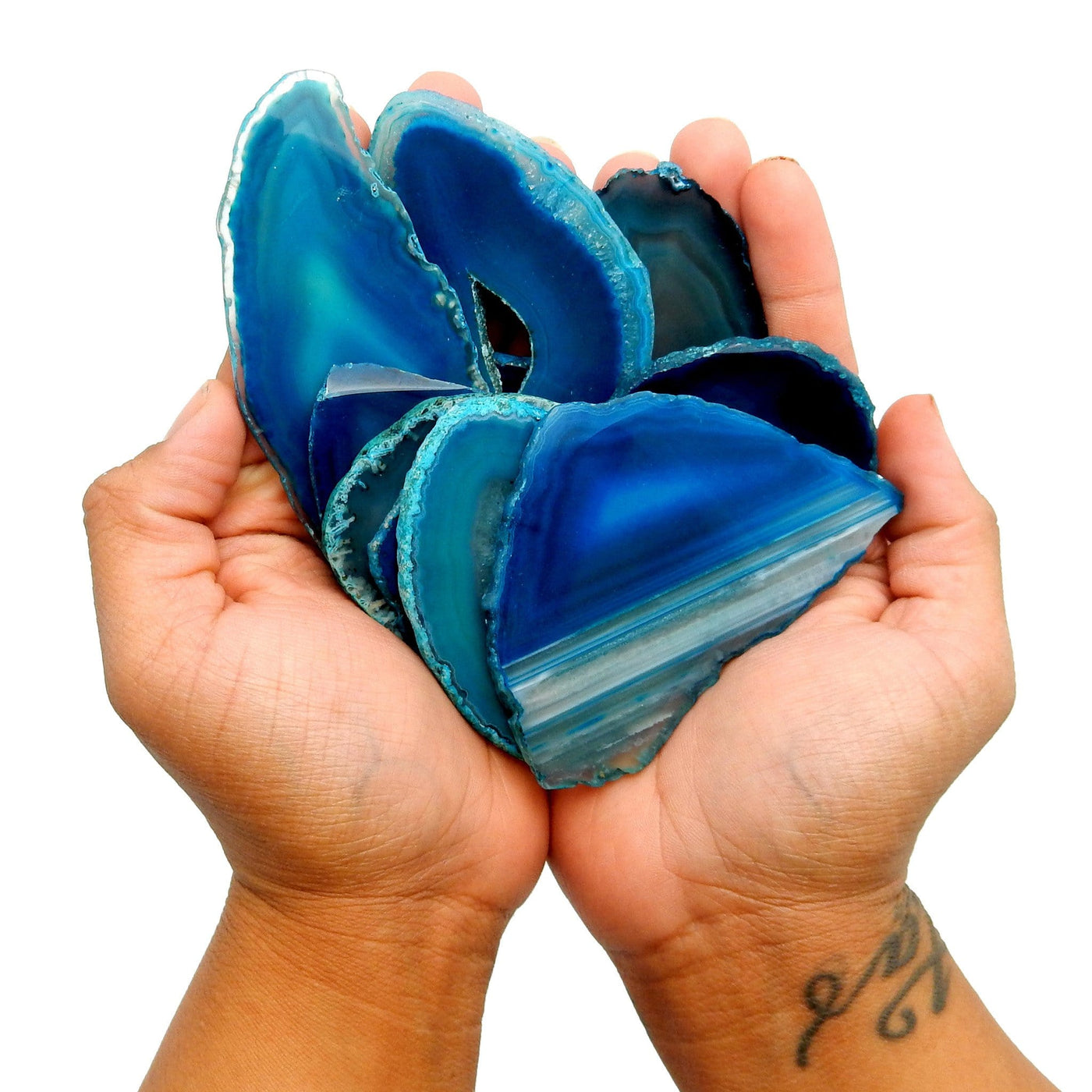 Hand holding 8 pieces of the Teal Agate Slices in a Size number 1