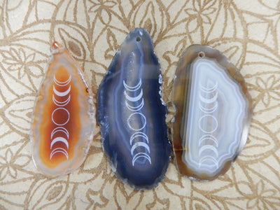 Picture of three  of our agate slices. red/orange, black and natural tone.