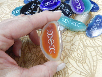 Picture of one of our orange agate slices being held for size reference.