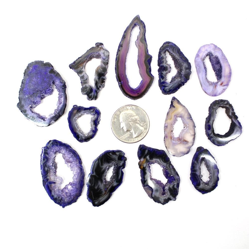 12 Dark Purple Geode Slice Around a Quarter Coin on White Background.