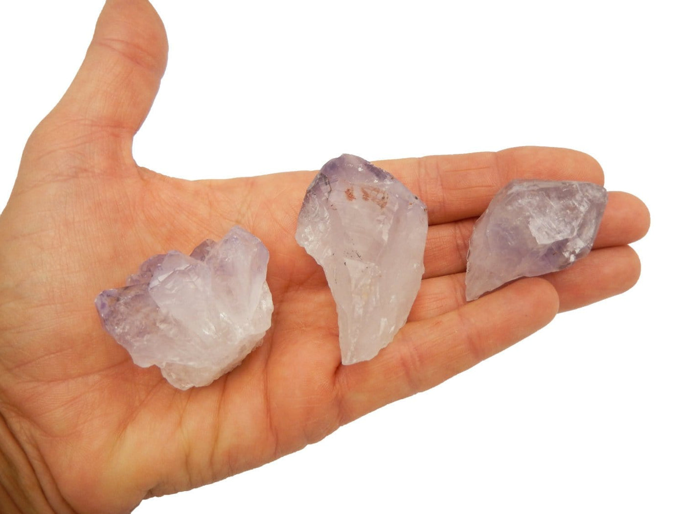 3 single amethyst points being held for size reference.