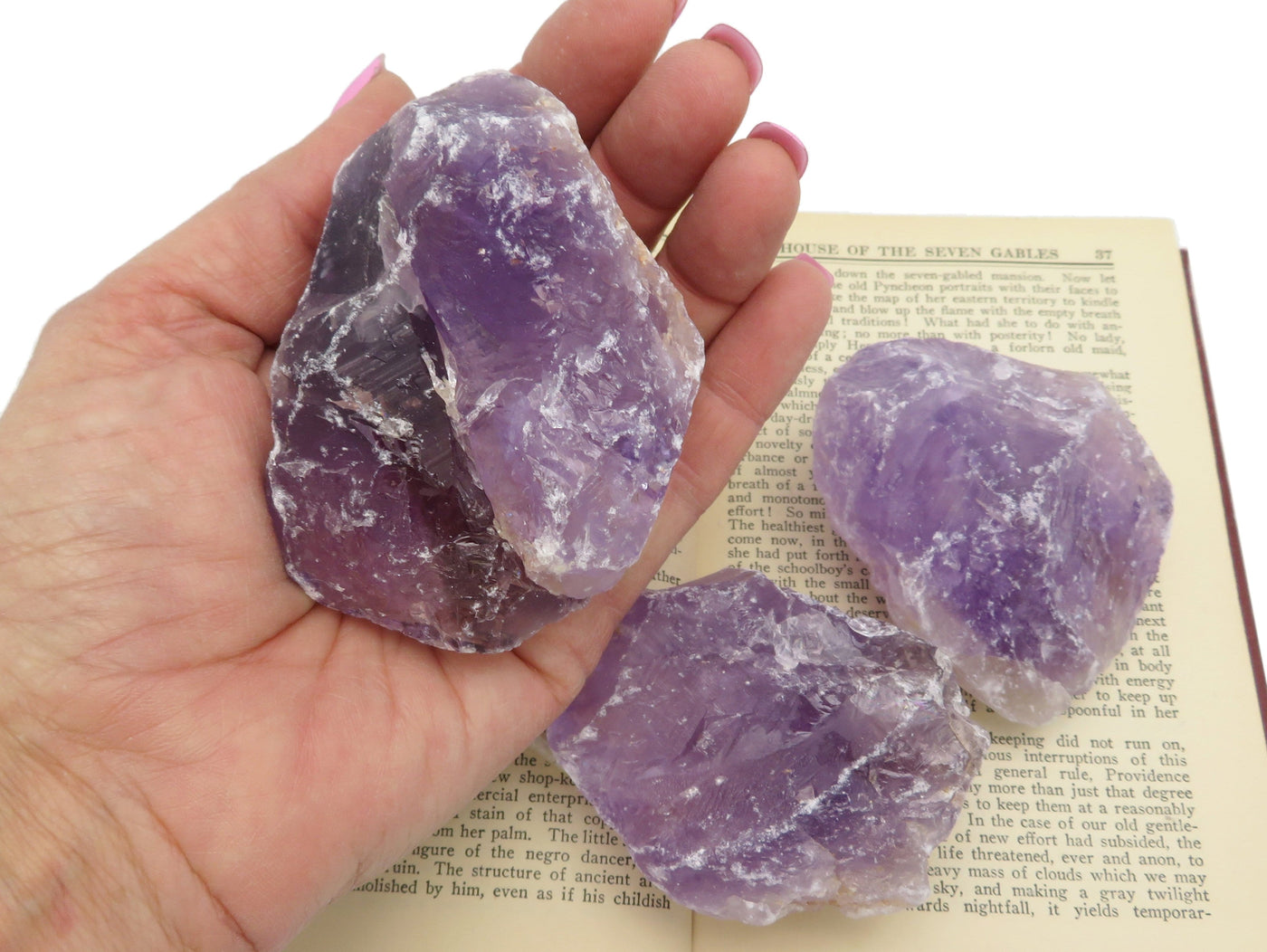 Natural Raw Amethyst Stone being held for size reference.