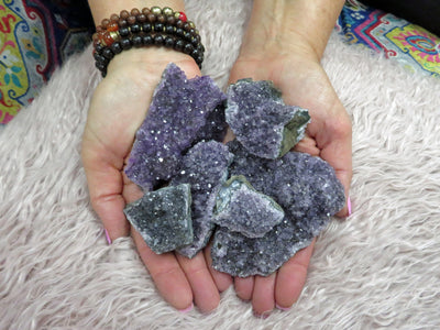 picture of amethyst clusters crystal geode pieces, Multiple amethyst clusters are being held with both hands for size and quantity reference.