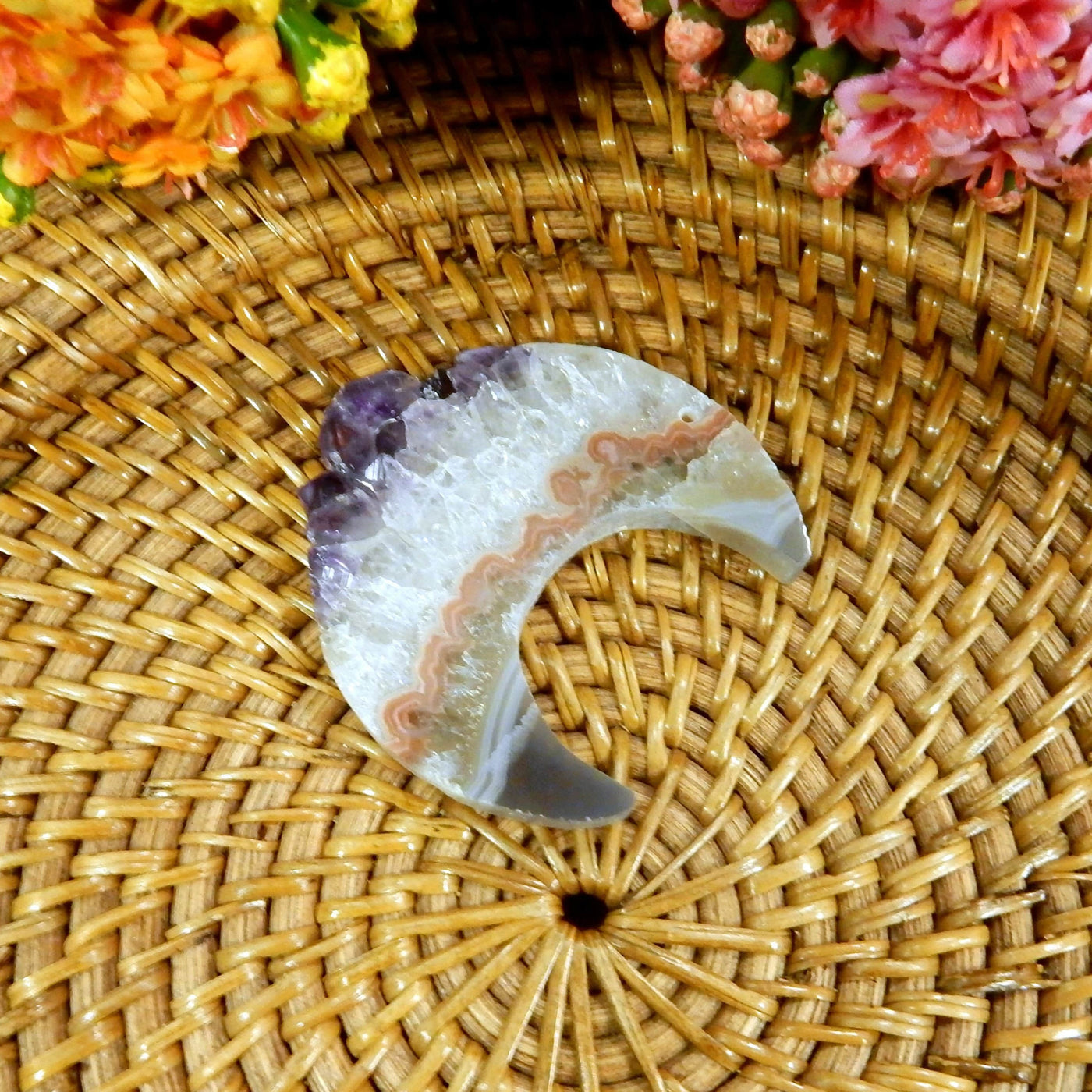 large drilled amethyst half moon with decorations in the background