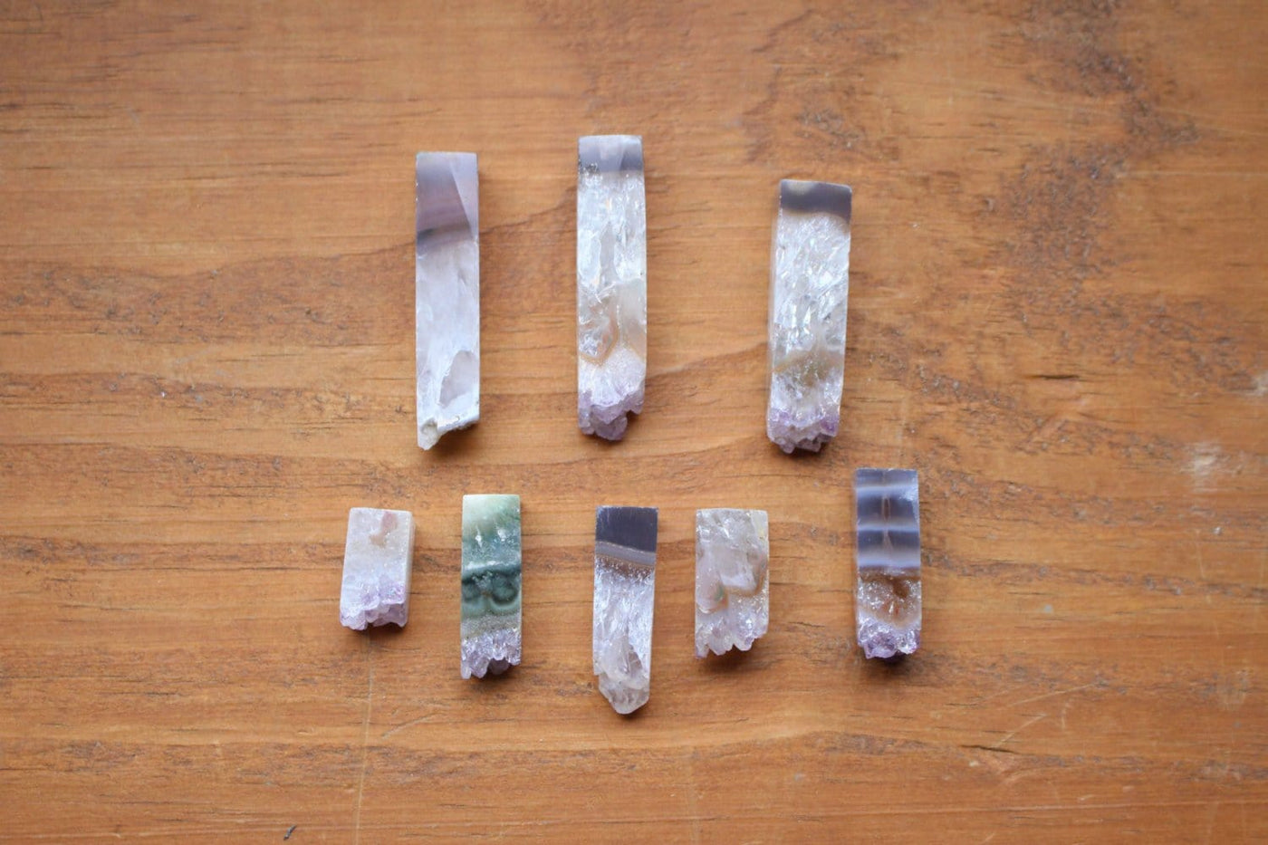 8 amethyst slices in different sizes on wooden background