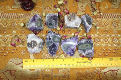 8 Amethyst Stalactites next to a measuring tape for size reference 