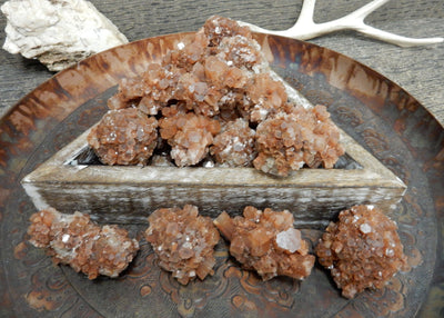 Multiple of Extra Large Aragonite Rods on a brown plate.