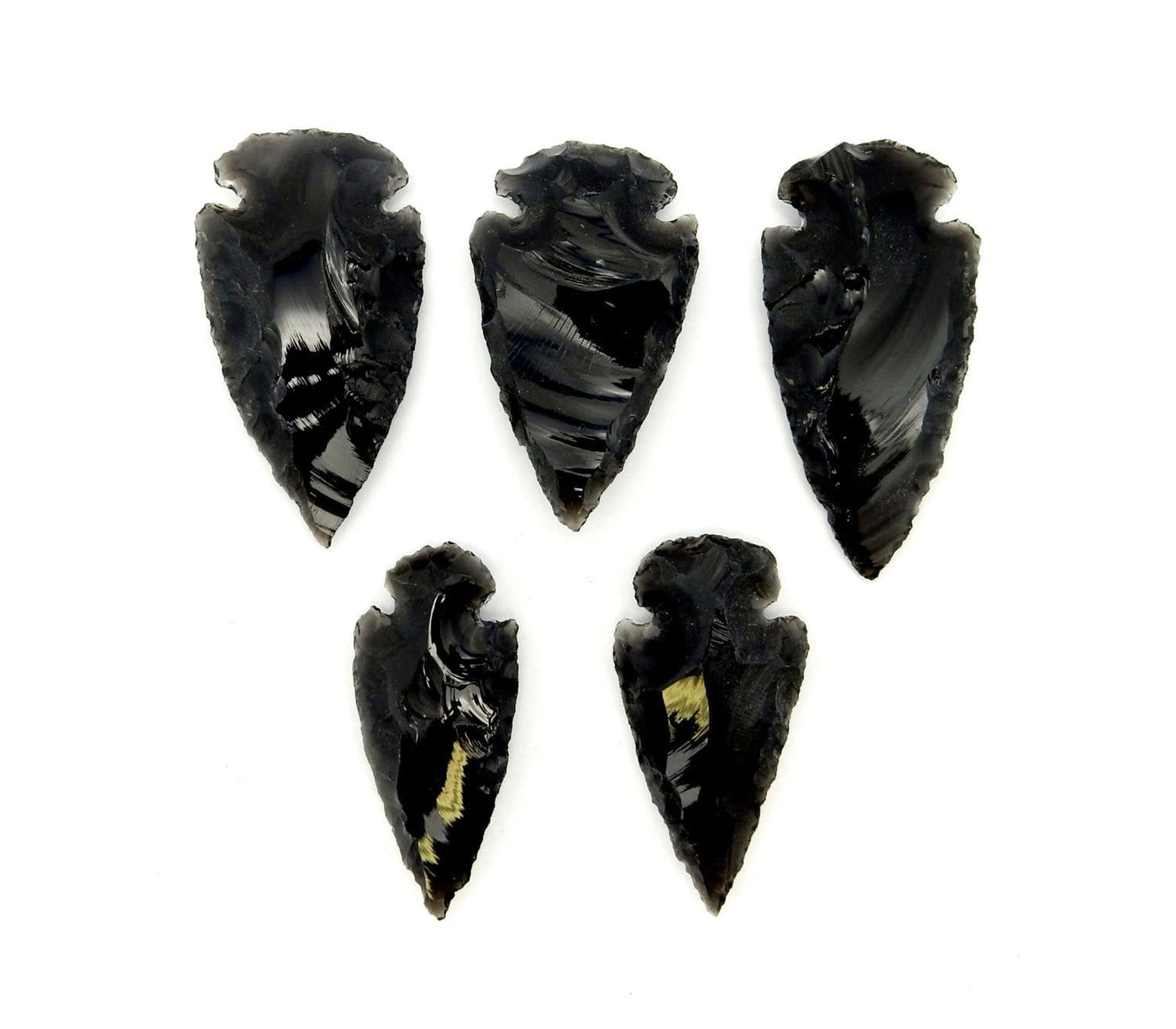 five black obsidian arrowheads on a white background.