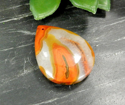 Up close shot of Red Chinese Agate Teardrop Shaped Bead on black background