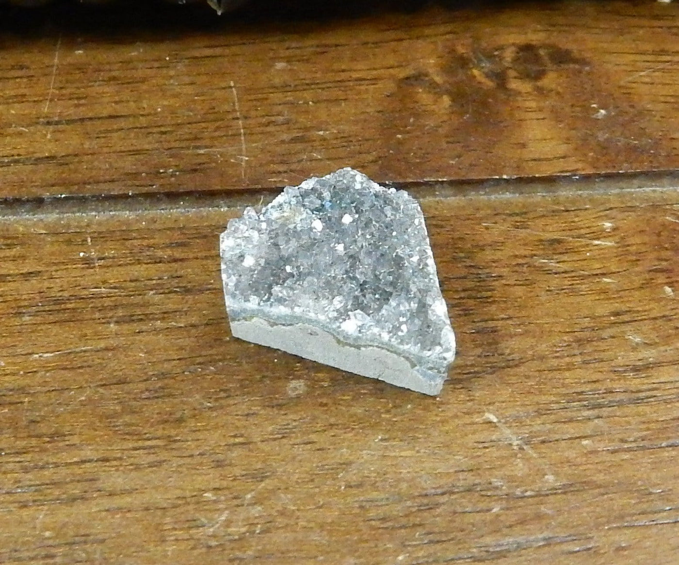 Druzy Diamond Drilled Cabochon, 1 laid on a table shown from top/side view for thickness reference