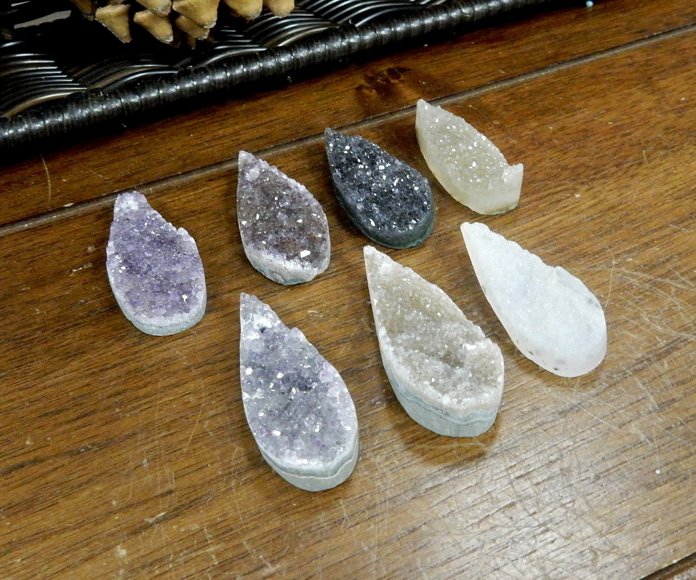 7 Druzy Teardrop Top Center Drilled Beads laid out and shown from side to reference thickness