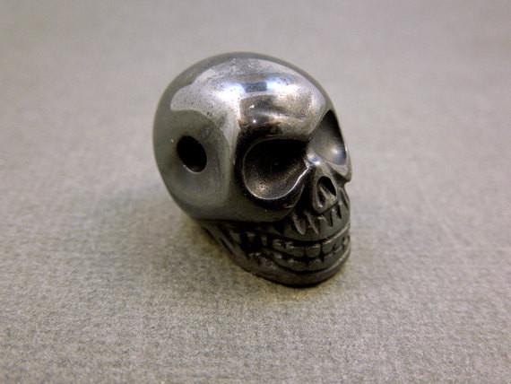 close up of one grey hematite skull bead for details