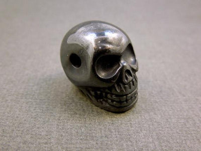 close up of one grey hematite skull bead for details