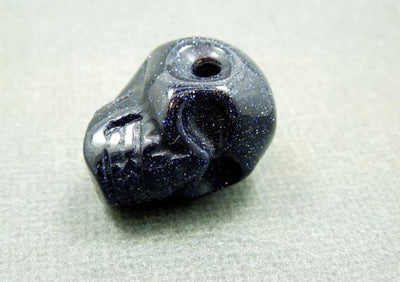 close up of one purple goldstone skull bead for details
