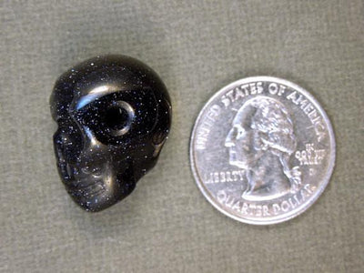 one purple goldstone skull bead with quarter for size reference