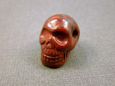 close up of one red brecciated jasper skull bead for details