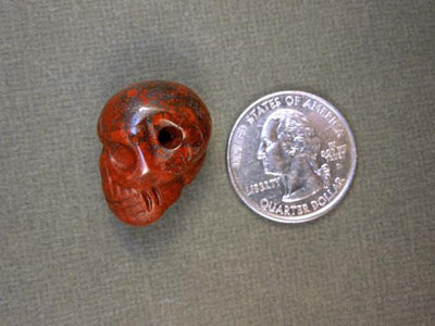 one red brecciated jasper skull bead with quarter for size reference