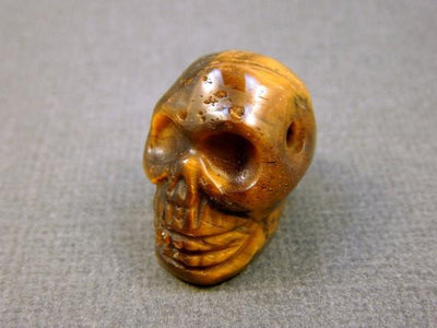 close up of one tiger eye skull bead for details