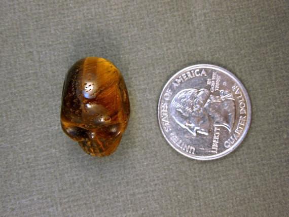 one tiger eye skull bead with quarter for size reference