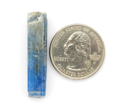 blue kyanite blade next to a quarter