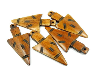 multiple carved bone arrowheads displayed to show the differences in the color shades 