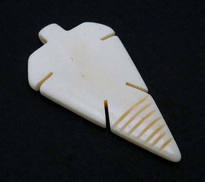 angled shot of Carved Bone Arrowhead Top Side Drilled Bead on black background