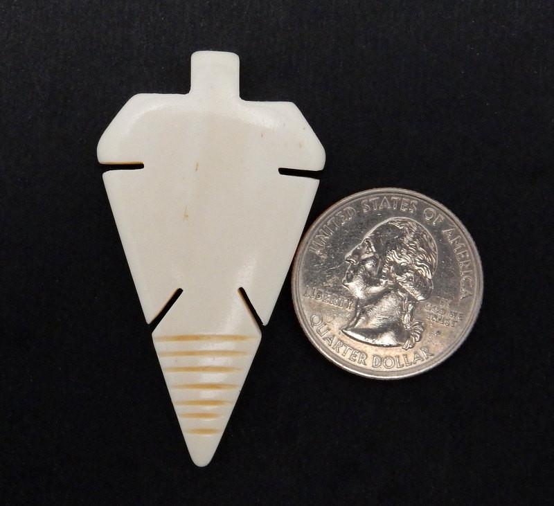 Carved Bone Arrowhead Top Side Drilled Bead  next to a quarter for size reference