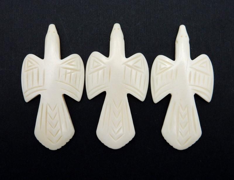 3 bone carved crosses on a black background