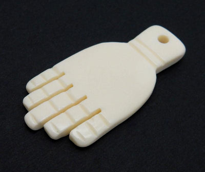 Fancy White Carved Bone Hand Top Drilled Bead on black background