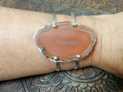 Orange Agate Slice on Electroplated 24k Gold Adjustable Bracelet on a wrist.