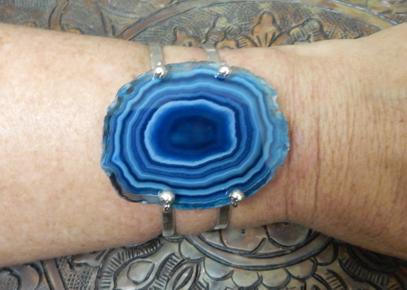 Blue Agate Slice with Adjustable Bracelet in silver on a wrist.