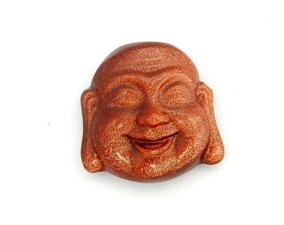 up close shot of Goldstone Buddha Head Cabochon on white background