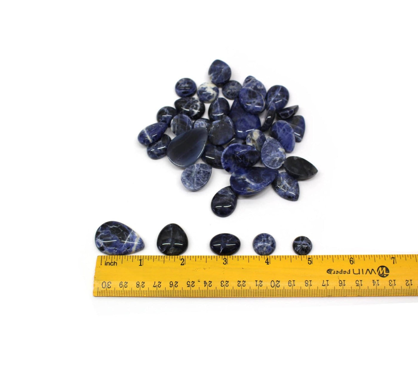 1/4 pound of blue sodalite mixed shapes cabochons next to a ruler for size reference 