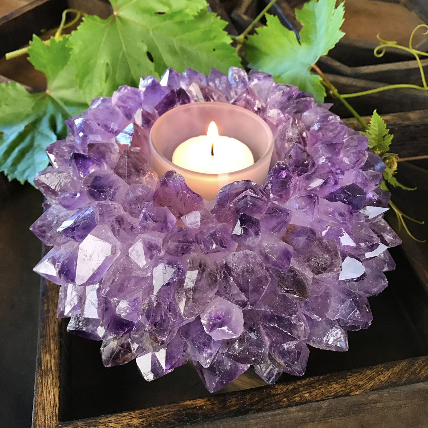 large amethyst point candle holder with candle burning inside of it
