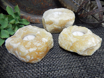 3 Mexican Orange Calcite Candle Holders with votives in them
